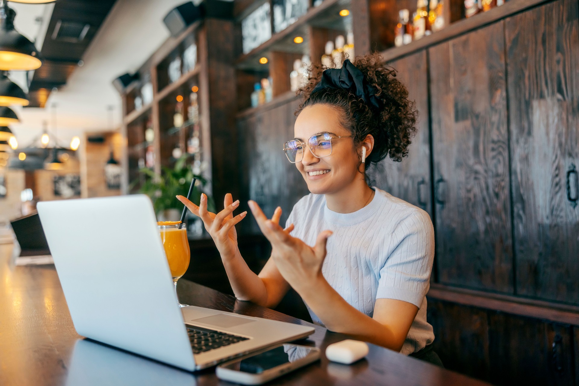 Portrait of interracial freelancer sitting in cafe and having conference call on laptop.